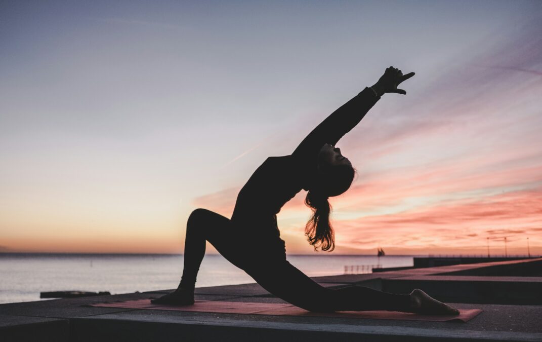 Yogi practicing yoga at sunset, symbolizing tranquility and mindfulness at yoga and wellness retreats in Bali.